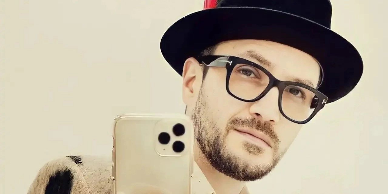 Fashionable young man in a stylish small brim fedora, taking a selfie, showcasing a modern twist on classic hat styles