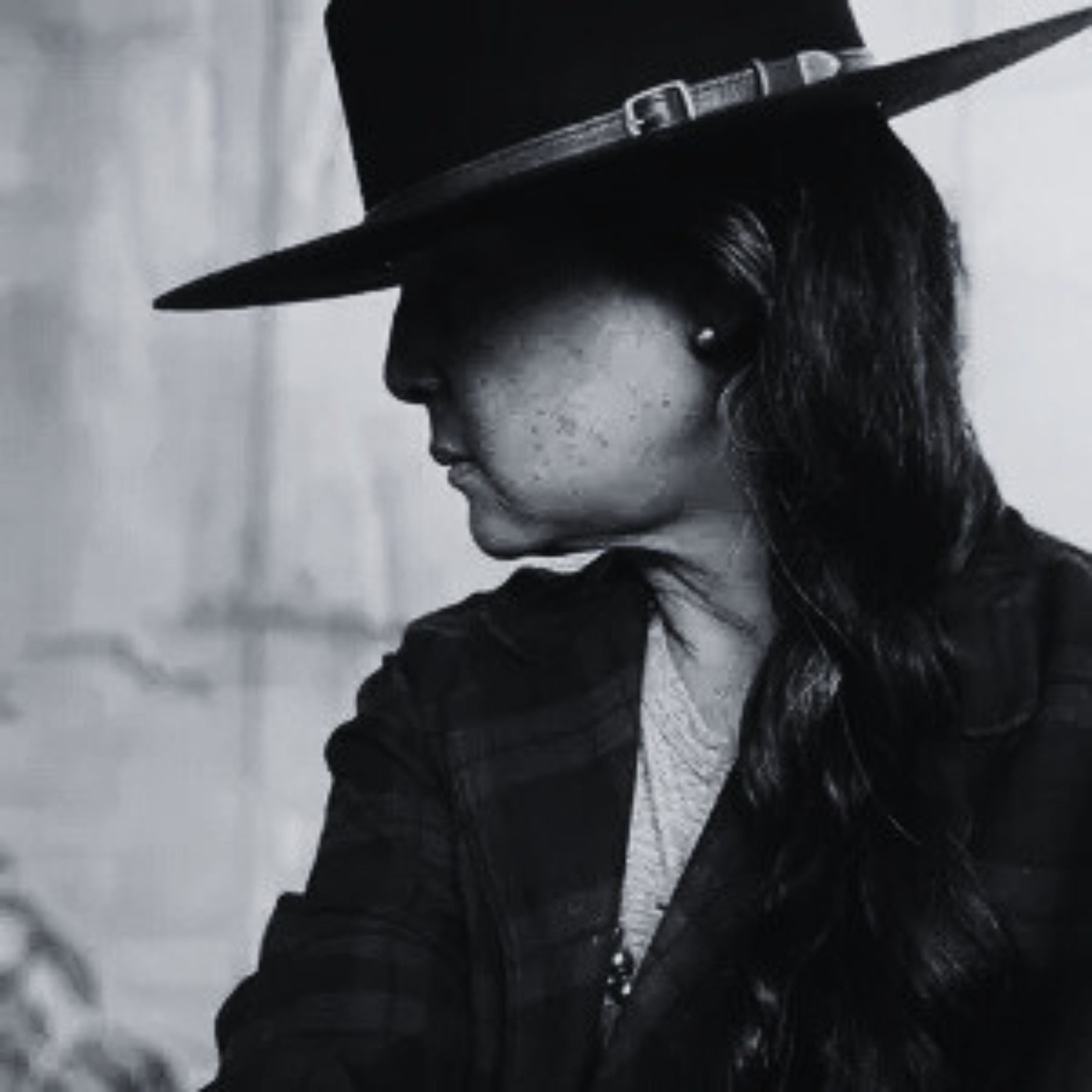 Person wearing a wide-brimmed hat in black and white