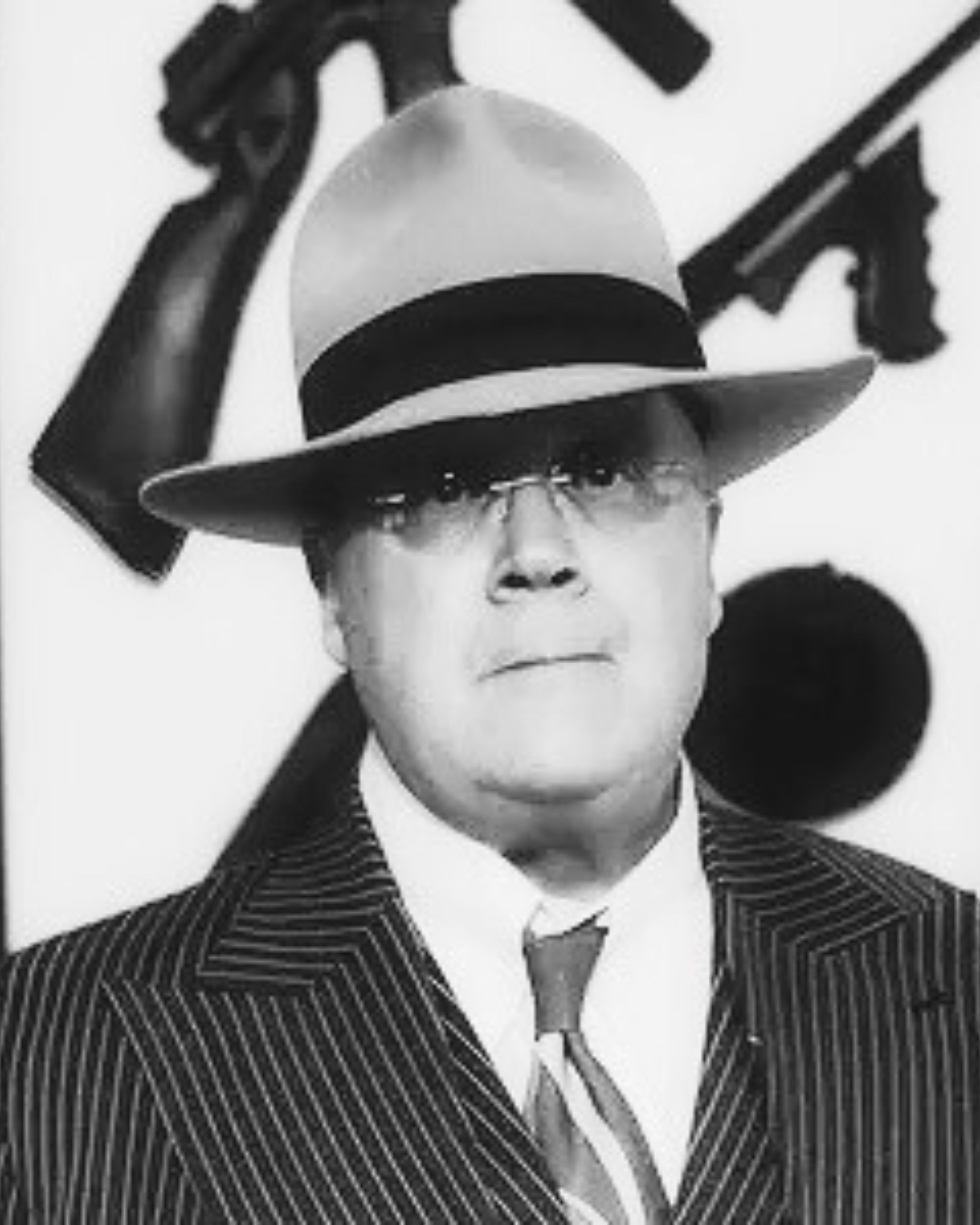 Black and white photo of a man wearing an Agnoulita hat and suit with a decorative background