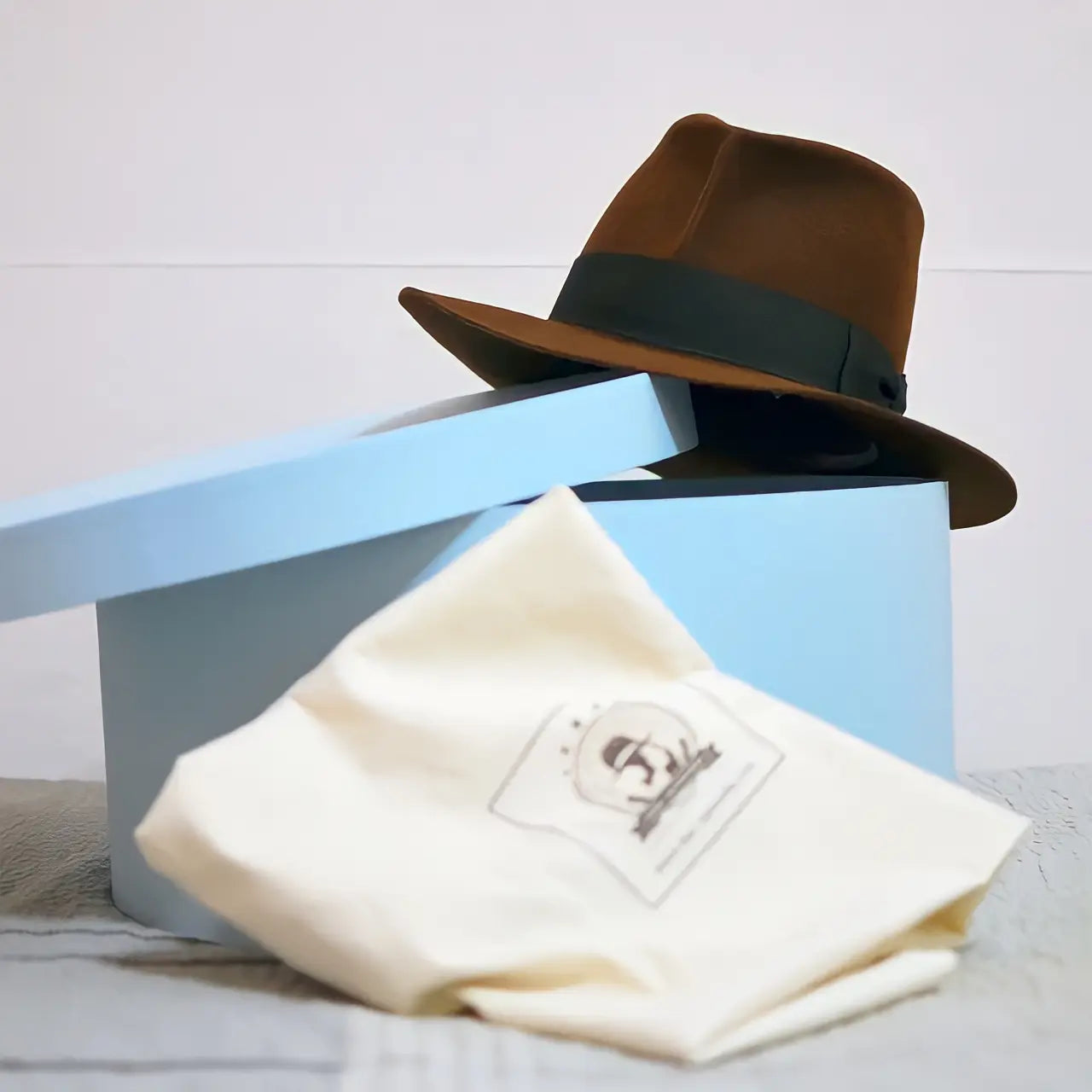 Agnoulita Hats' hatbox and organic cotton protective bag for safe and stylish storage.