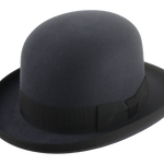 The Jubilee bowler hat posed against a soft, light background, accentuating its dark slate grey color and classic silhouette.