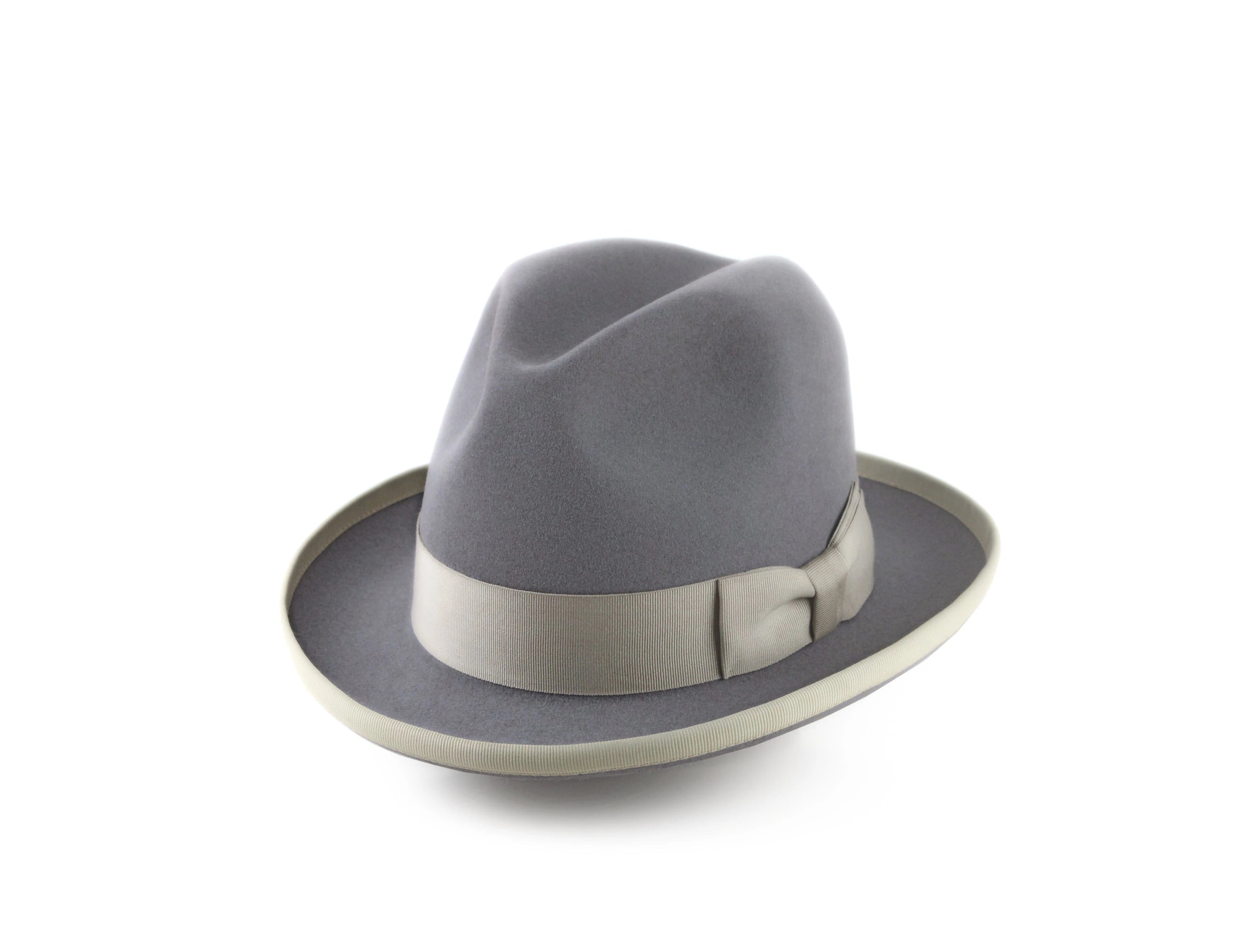 An elegant elderly man with a warm smile poses in a sunlit autumn park, wearing one of Agnoulita's best fedoras in distinguished brown, perfectly paired with his rich coat and scarf amidst the vibrant yellow fall foliage.