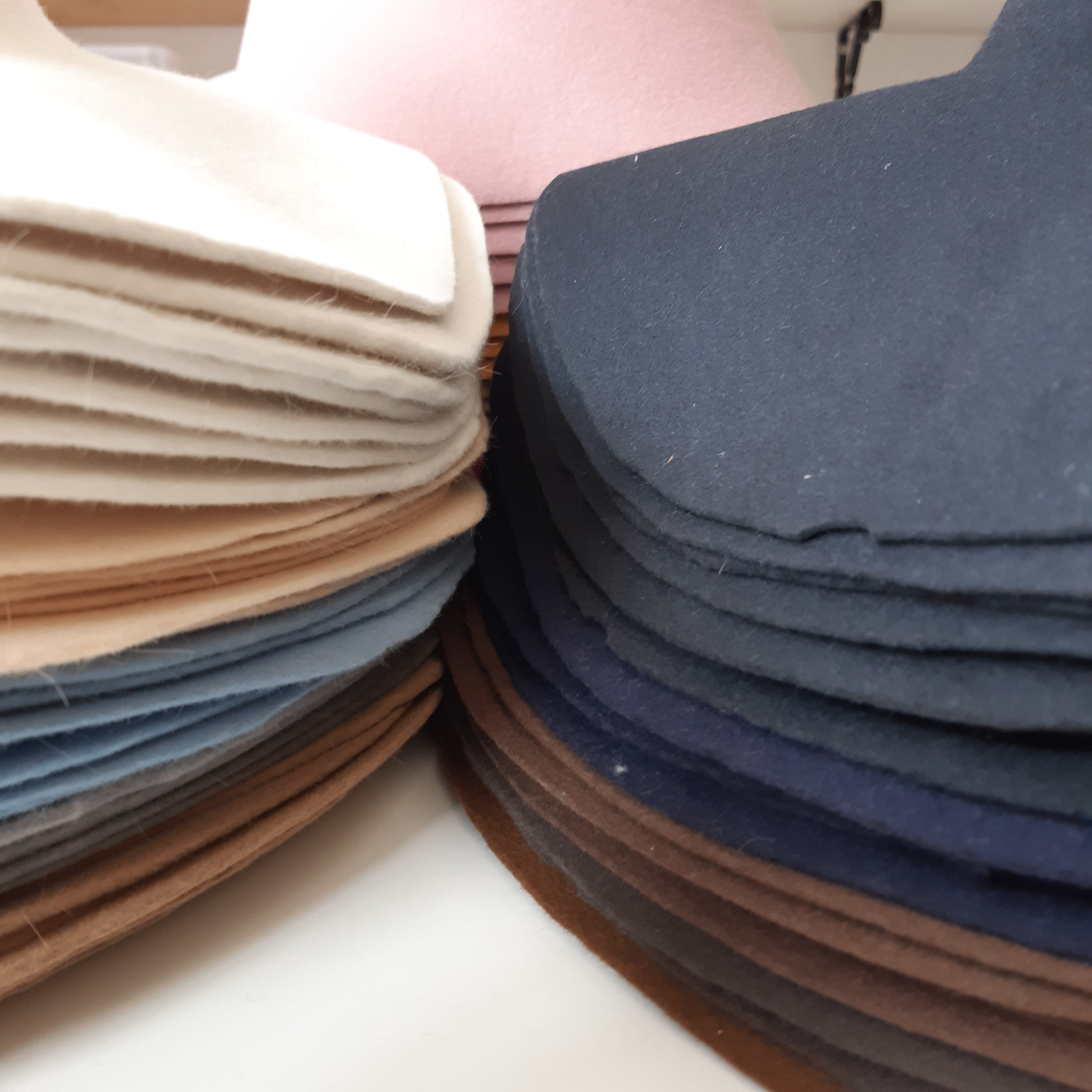 Three stacks of hat bodies in various colors for sale