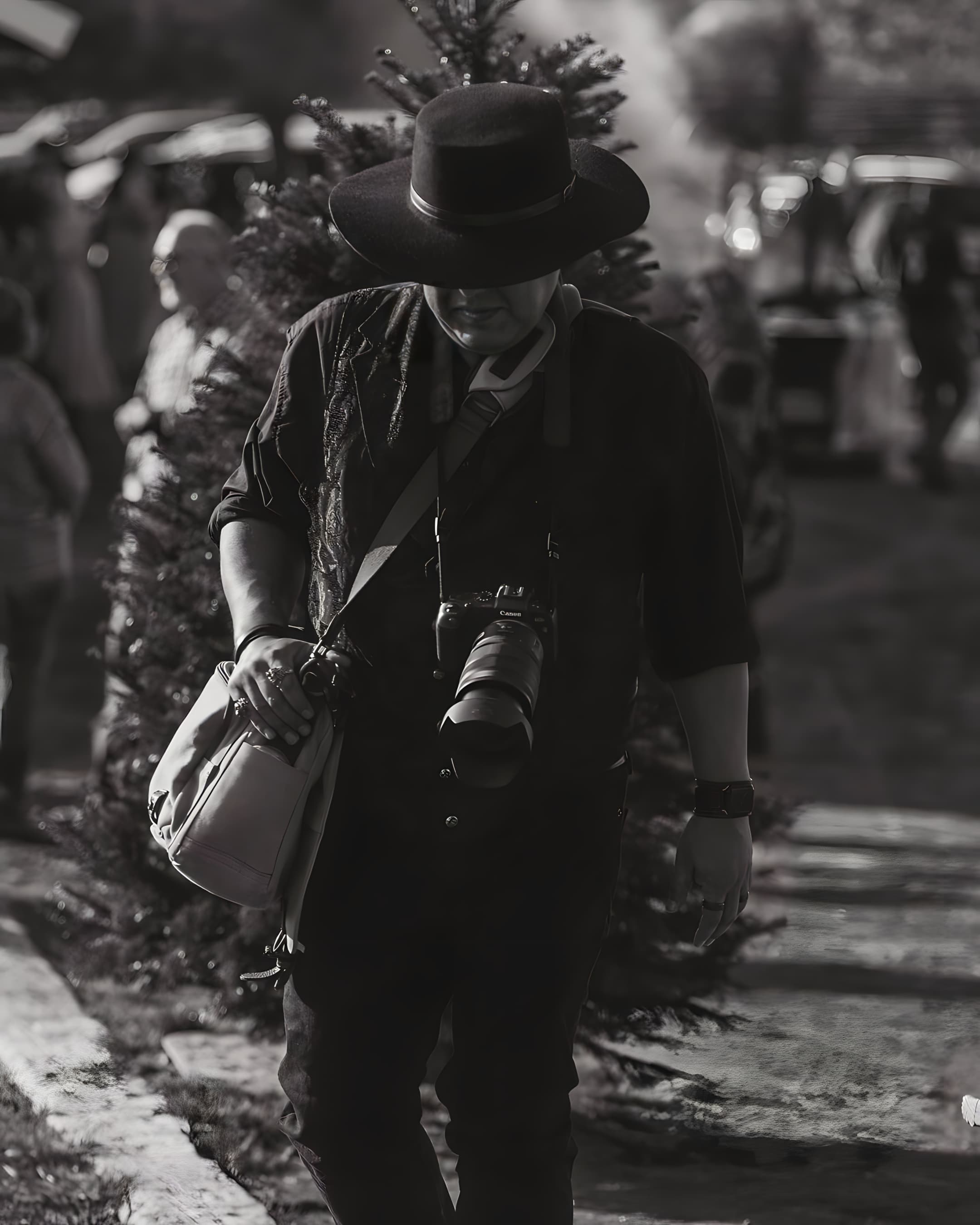 Black and white cover image for the Frontier Collection, featuring a photo reporter with cameras hanging, walking through a festival, distinguished by his iconic Agnoulita Galloper hat