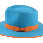 Detailed view of the Equinox fedora's 1" grosgrain ribbon hatband in orange, set against the aqua fur felt body