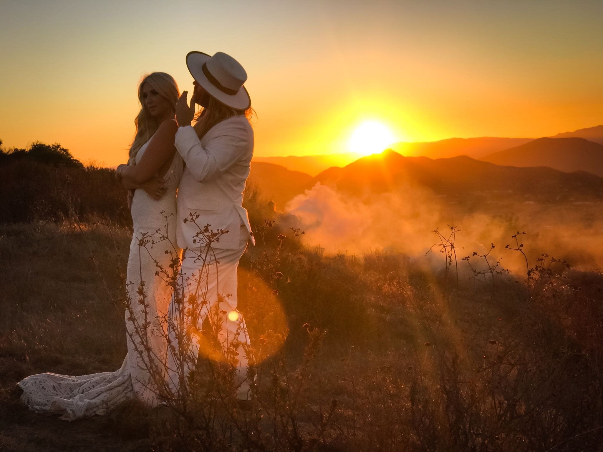 sunset photo of newly wed couple with an Agnoulita hat